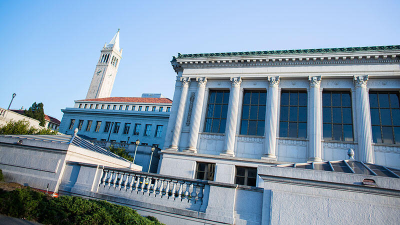 Image of library building with columns and Campanile tower in background